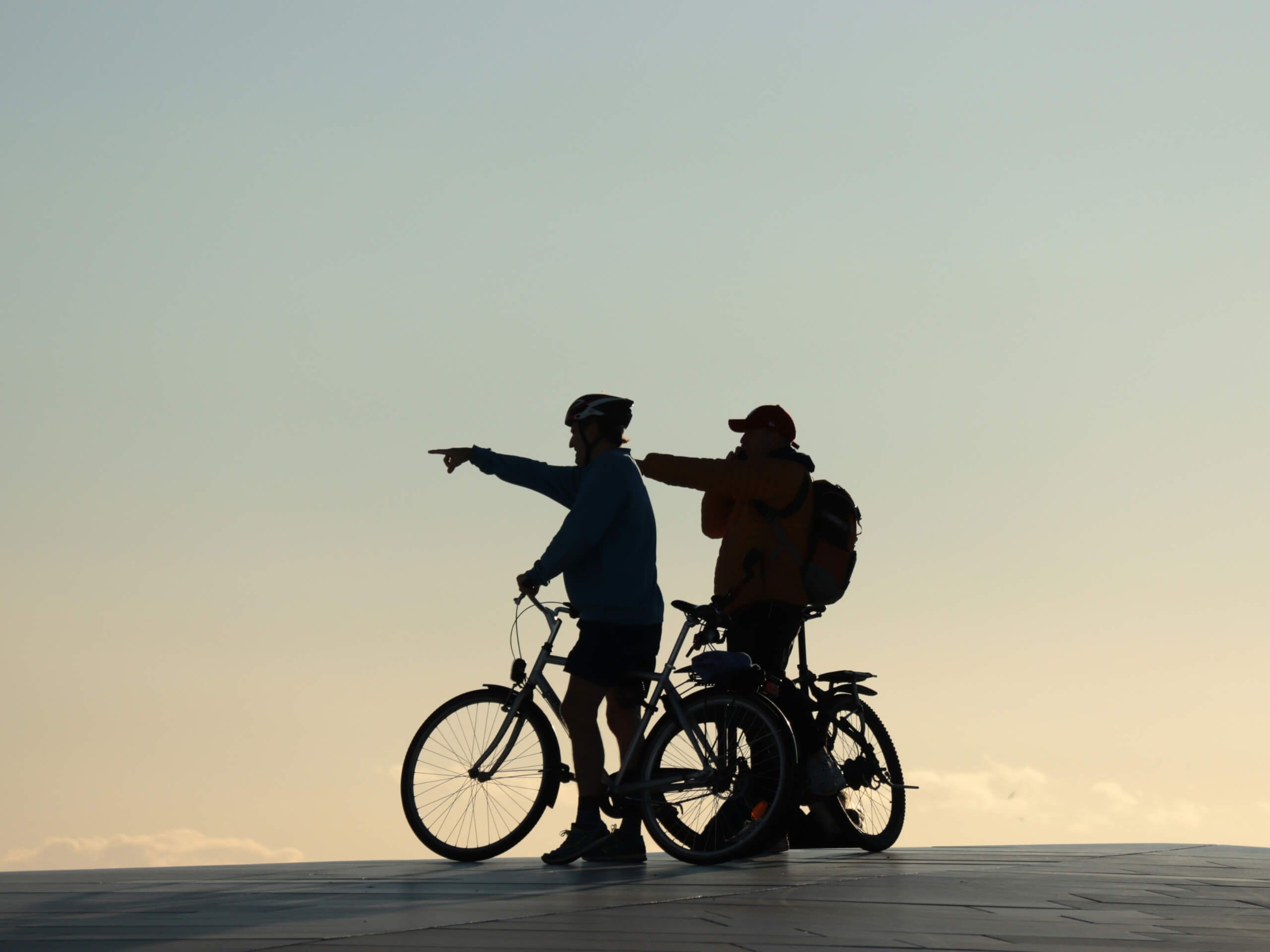 Two cyclists pointing ahead